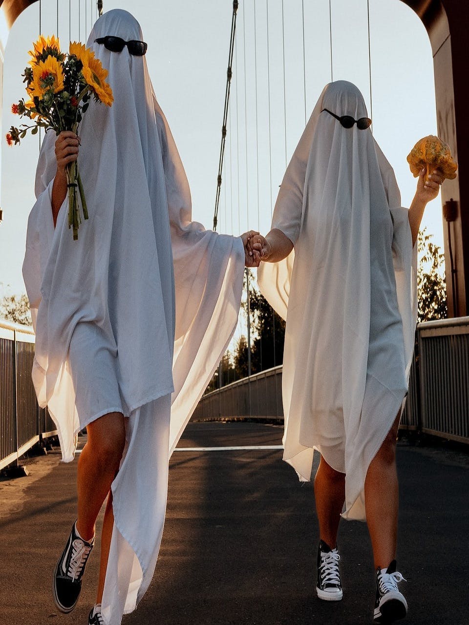 Two people dressed as ghosts in sheets walking